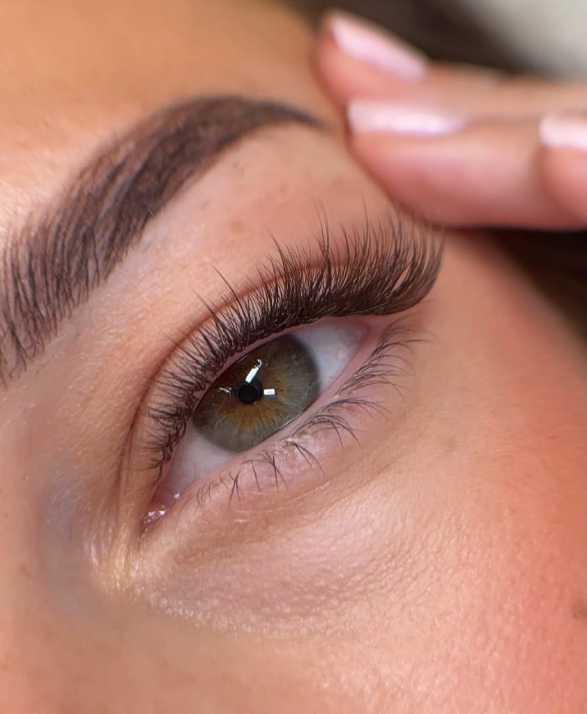 Cat-eye volume lash extensions with laminated, tinted brows brushed into a soft arch
