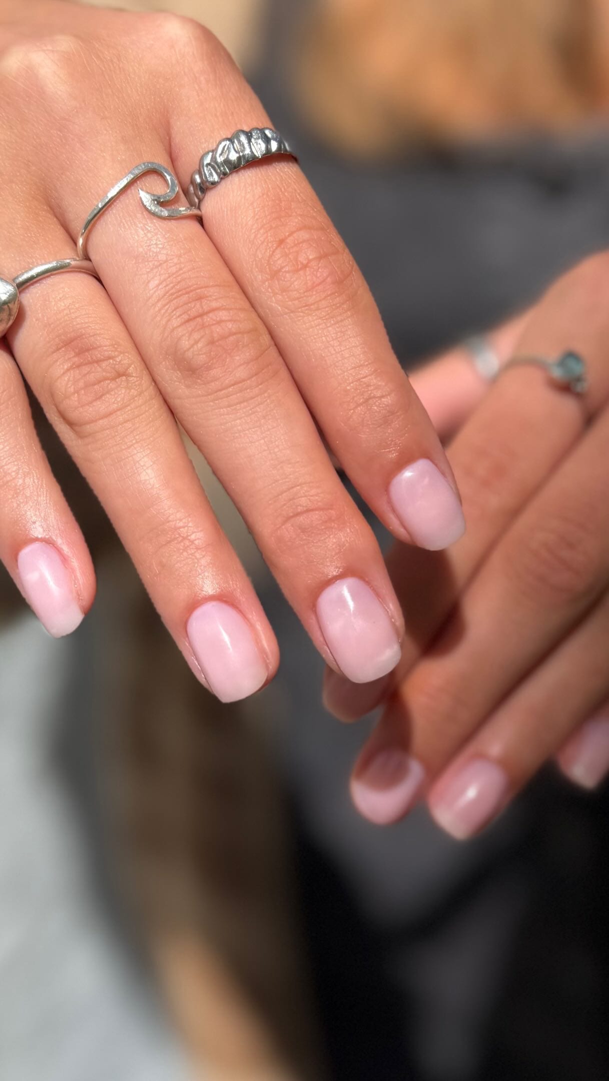 Short milky-pink gel manicure on rounded natural nails